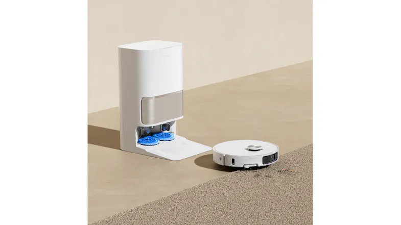 Dreame robot vacuum next to its dock, showing the blue mop pads being cleaned automatically Dreame robot vacuum next to its dock, showing the blue mop pads being cleaned automatically