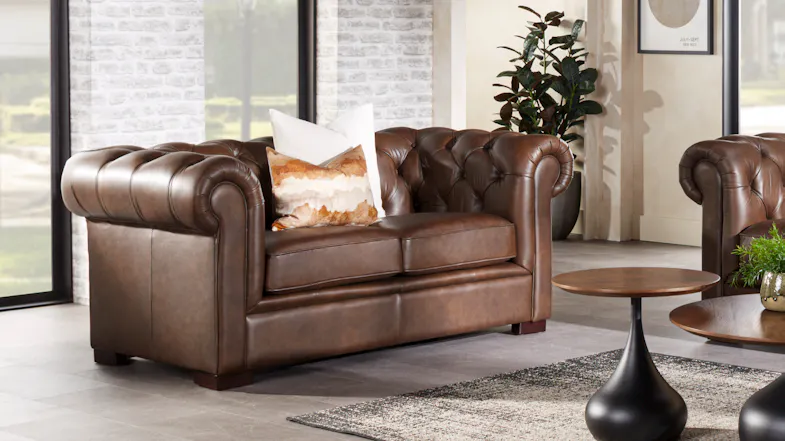 Front view of a classic brown leather Chesterfield 2-seater sofa Front view of a classic brown leather Chesterfield 2-seater sofa