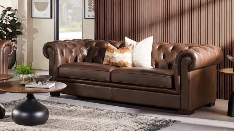 Front view of a classic brown leather Chesterfield 3-seater sofa Front view of a classic brown leather Chesterfield 3-seater sofa
