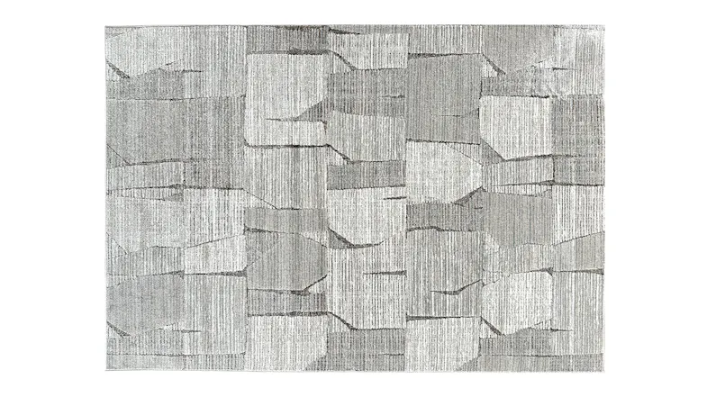 Rectangular rug with a blocky, abstract design in various shades of grey. Rectangular rug with a blocky, abstract design in various shades of grey.