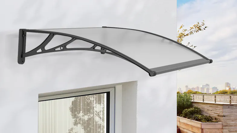 An awning installed above a window on a white wall with outdoor view An awning installed above a window on a white wall with outdoor view