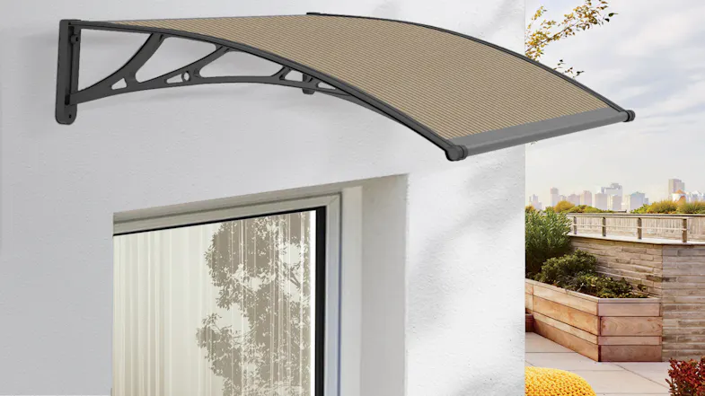 An awning is installed above a window on a white wall with an outdoor view An awning is installed above a window on a white wall with an outdoor view