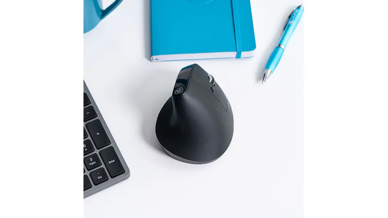 Ergonomic desk layout with wireless mouse, blue notebook, and pen Ergonomic desk layout with wireless mouse, blue notebook, and pen