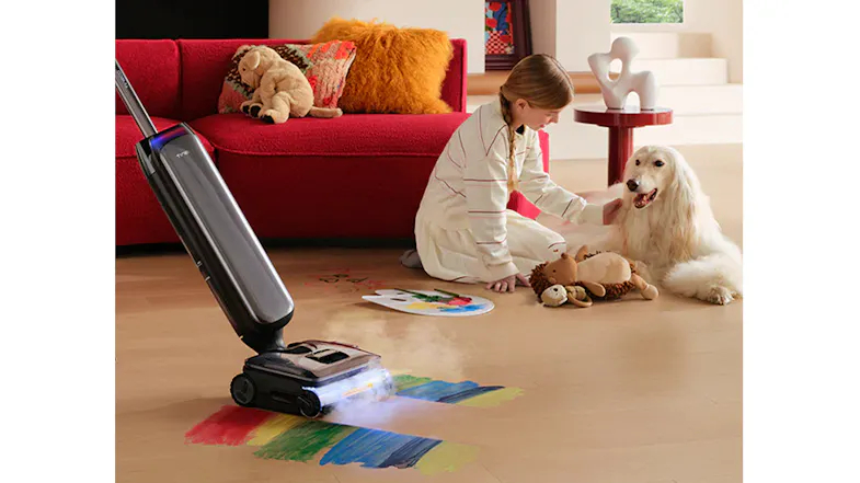 A person is cleaning colourful paint spills beside a dog A person is cleaning colourful paint spills beside a dog