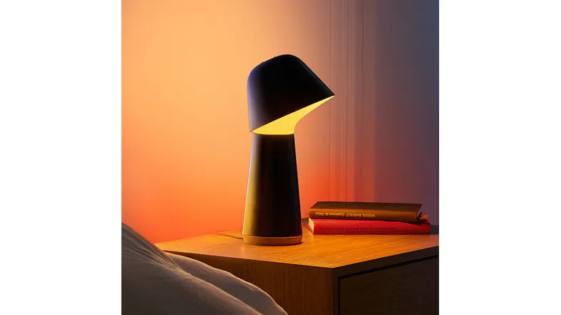 A lamp on a wooden table beside books A lamp on a wooden table beside books