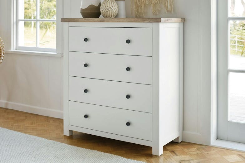 Taylor 4 Drawer Tallboy with décor sitting on top, against a bedroom wall between two windows. Taylor 4 Drawer Tallboy with décor sitting on top, against a bedroom wall between two windows.