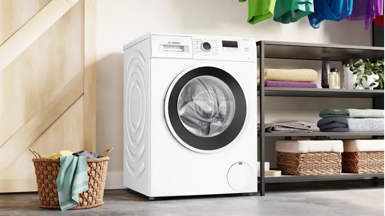 A Bosch washer beside metal shelves and a woven laundry basket A Bosch washer beside metal shelves and a woven laundry basket