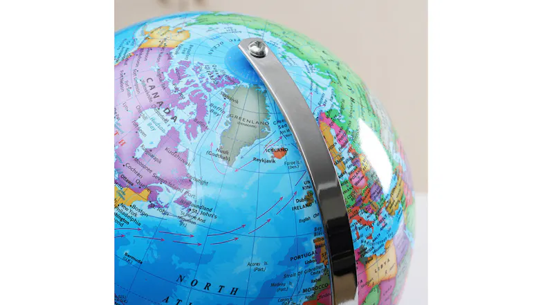 Close-up of world globe with bright map details and sturdy silver mounting hardware Close-up of world globe with bright map details and sturdy silver mounting hardware