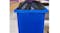 A hand pulling the purple drawstring to close a black trash bin A hand pulling the purple drawstring to close a black trash bin