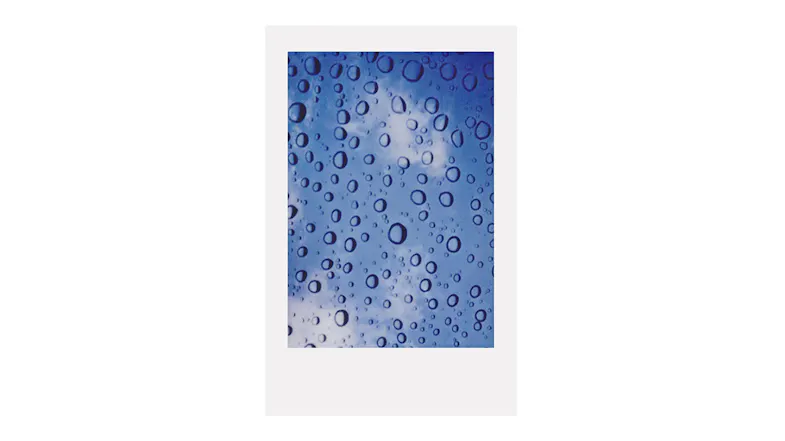 A photo of a blue sky with water droplets on glass A photo of a blue sky with water droplets on glass