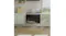 Built-in oven under cooktop in grey kitchen with tile backsplash Built-in oven under cooktop in grey kitchen with tile backsplash