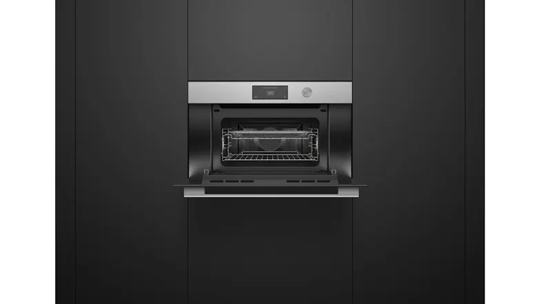 Microwave oven with door open, showing interior cavity, wire rack, and fan at the back Microwave oven with door open, showing interior cavity, wire rack, and fan at the back