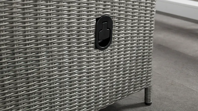 Detail shot of the side of a grey wicker armchair showing the built‑in black recliner lever against the woven texture Detail shot of the side of a grey wicker armchair showing the built‑in black recliner lever against the woven texture