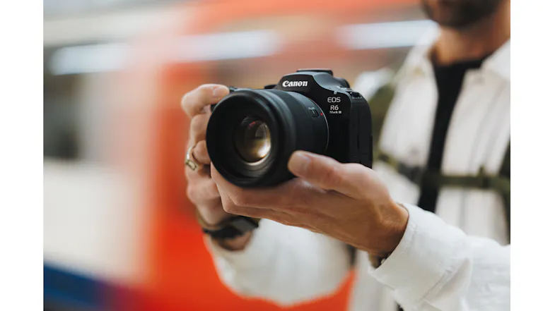 Close-up of hands adjusting the lens on a Canon EOS R6 Mark III mirrorless camera Close-up of hands adjusting the lens on a Canon EOS R6 Mark III mirrorless camera
