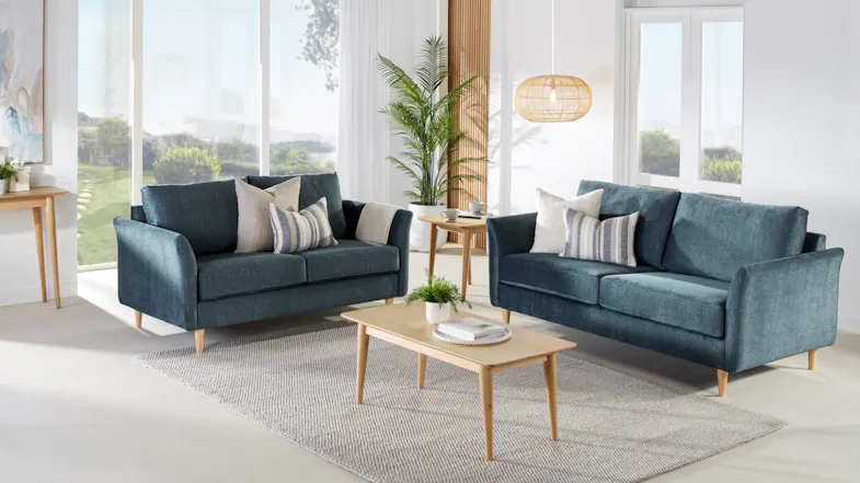 An elegant Finesse 2 Piece Fabric Lounge Suite in a modern living room with large windows An elegant Finesse 2 Piece Fabric Lounge Suite in a modern living room with large windows