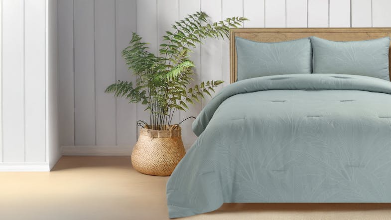 Close-up of a Sage coloured bedspread with subtle leaf patterns, paired with a woven basket holding a green plant. Close-up of a Sage coloured bedspread with subtle leaf patterns, paired with a woven basket holding a green plant.
