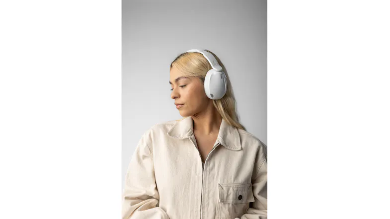 Person in beige jacket with white headphones, eyes closed Person in beige jacket with white headphones, eyes closed