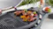 Ziggy Classic 2 Burner BBQ with one half hotplate and one grill plate, cooking chicken drumsticks Ziggy Classic 2 Burner BBQ with one half hotplate and one grill plate, cooking chicken drumsticks