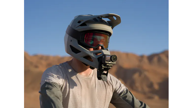 Helmet with a chin-mounted camera and goggles in a desert landscape Helmet with a chin-mounted camera and goggles in a desert landscape