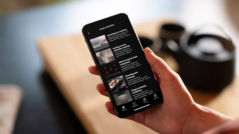 Smartphone screen showing cooktop user guides in the kitchen Smartphone screen showing cooktop user guides in the kitchen