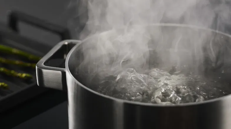 Close-up of boiling water in a stainless steel pot on the induction cooktop Close-up of boiling water in a stainless steel pot on the induction cooktop