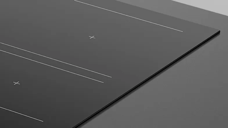 Close-up of the cooktop’s corner, showing the smooth black glass finish Close-up of the cooktop’s corner, showing the smooth black glass finish