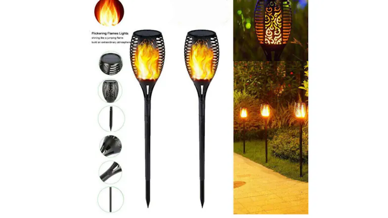 Two solar torch lights with a flickering flame effect are installed along a garden walkway Two solar torch lights with a flickering flame effect are installed along a garden walkway