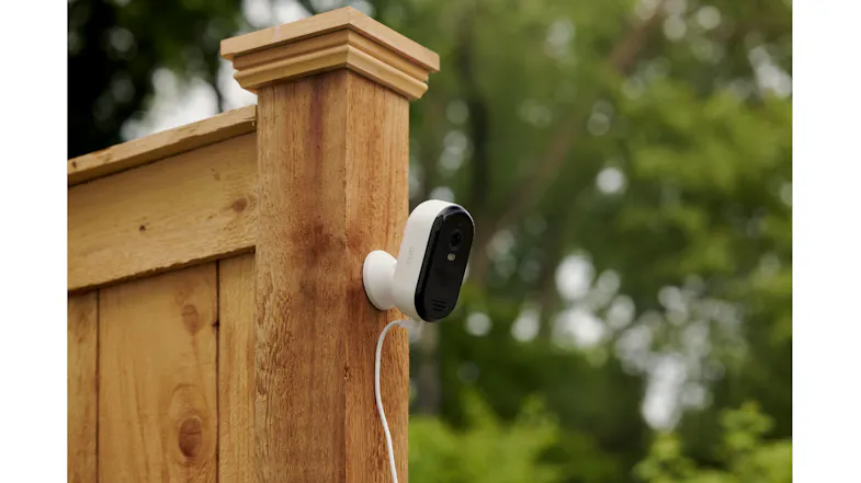 Arlo camera with cable mounted on a wooden fence post in the garden Arlo camera with cable mounted on a wooden fence post in the garden