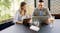 Two people working at a café table with a hotspot and a cybersecurity overlay Two people working at a café table with a hotspot and a cybersecurity overlay