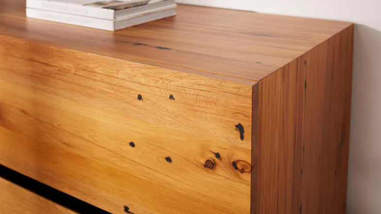 Close-up of the rustic, natural wood grain and knots on the top corner of the four-drawer tallboy Close-up of the rustic, natural wood grain and knots on the top corner of the four-drawer tallboy