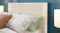 Bed with a white grooved headboard and tropical pillows Bed with a white grooved headboard and tropical pillows