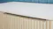 Close-up view of the cabinet with a wood slatted front panel Close-up view of the cabinet with a wood slatted front panel