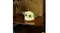 Grogu LED character light is placed on a wooden shelf, softly glowing near a speaker and a plant Grogu LED character light is placed on a wooden shelf, softly glowing near a speaker and a plant