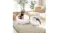 A small black dog and a cat relax side-by-side on two separate white elevated pet beds A small black dog and a cat relax side-by-side on two separate white elevated pet beds