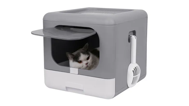 Grey foldable cat litter box with white base, front flap door, attached scoop, and a cat inside Grey foldable cat litter box with white base, front flap door, attached scoop, and a cat inside