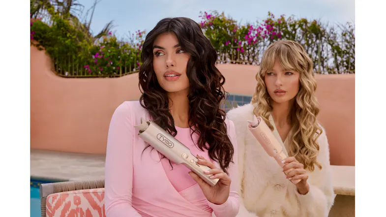 Two people holding a gold hair curler outdoors Two people holding a gold hair curler outdoors