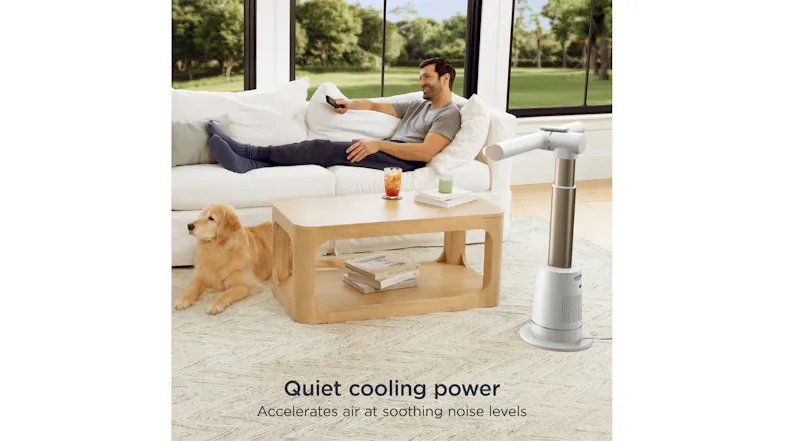 Man relaxing on a couch with a dog nearby, enjoying the fan's quiet cooling power Man relaxing on a couch with a dog nearby, enjoying the fan's quiet cooling power