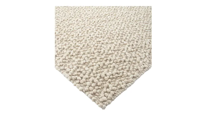 Close-up of the rug’s corner highlighting its thick, rounded wool loops and sturdy edge finish Close-up of the rug’s corner highlighting its thick, rounded wool loops and sturdy edge finish