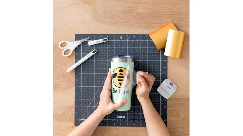 Applying a vinyl bee design to a tumbler using a transfer tape and tools Applying a vinyl bee design to a tumbler using a transfer tape and tools