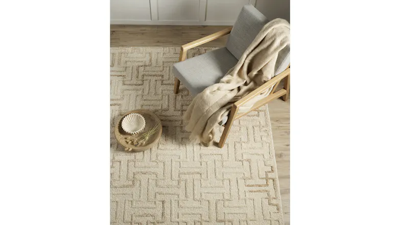Ecru geometric rug grounding a single light grey chair and small round table Ecru geometric rug grounding a single light grey chair and small round table