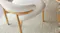 A close-up view of a dining chair showing a curved backrest and its textured upholstery A close-up view of a dining chair showing a curved backrest and its textured upholstery
