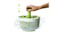 Hand-pumping green spindle on Spindola colander to spin and dry fresh salad leaves with water splashing Hand-pumping green spindle on Spindola colander to spin and dry fresh salad leaves with water splashing