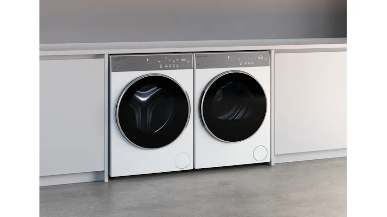 Washer and dryer pair installed side by side under a white countertop in a modern laundry setup Washer and dryer pair installed side by side under a white countertop in a modern laundry setup