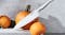 Angled view of a stainless-steel chef knife resting on pumpkins Angled view of a stainless-steel chef knife resting on pumpkins