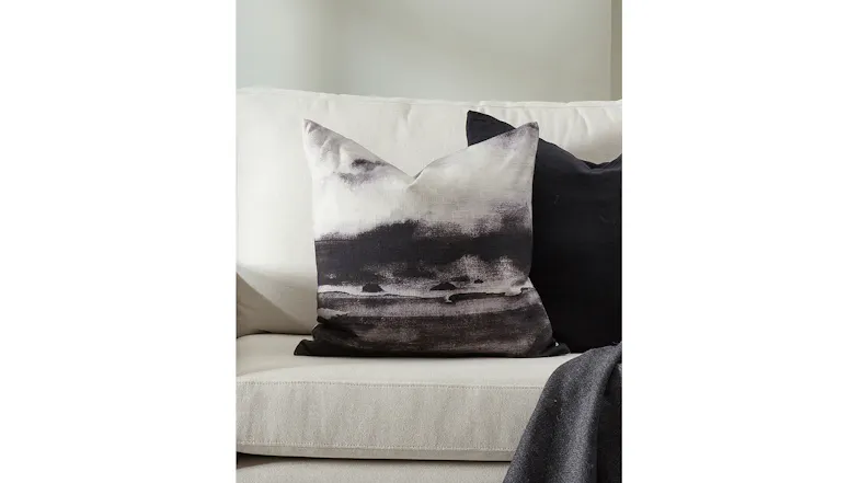 Close-up of a square cushion featuring a black and white painted landscape Close-up of a square cushion featuring a black and white painted landscape