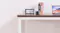 Close-up of a modern desk with books, a calendar, a black mug, and part of a laptop on the wooden top Close-up of a modern desk with books, a calendar, a black mug, and part of a laptop on the wooden top