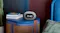 JBL Horizon 3 clock speaker sitting on a blue bedside table next to books and a bed JBL Horizon 3 clock speaker sitting on a blue bedside table next to books and a bed