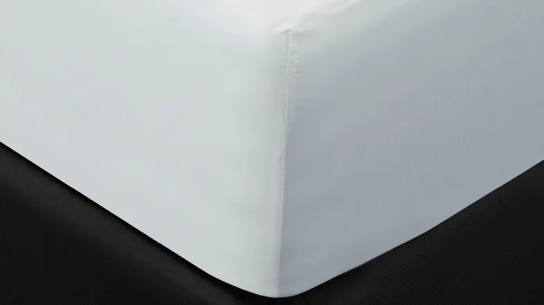 A close up view of a bed's edge showcases the sheet's quality A close up view of a bed's edge showcases the sheet's quality