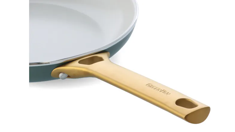 Detail shot of the sturdy gold handle attachment on a blue ceramic GreenPan frying pan Detail shot of the sturdy gold handle attachment on a blue ceramic GreenPan frying pan