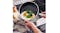 The frying pan is tilted over a plate as eggs and greens slide smoothly from the non‑stick surface The frying pan is tilted over a plate as eggs and greens slide smoothly from the non‑stick surface